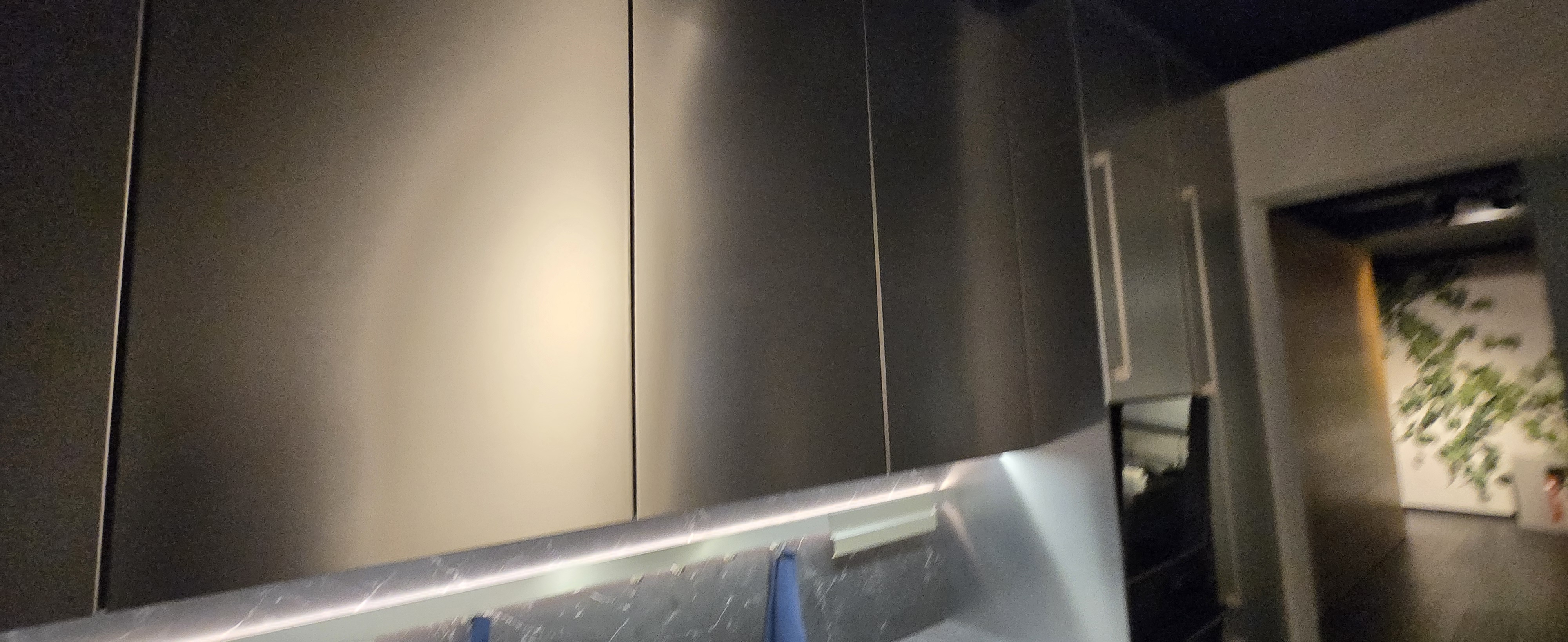 Integrated LED task lighting beneath dark wall cabinets
